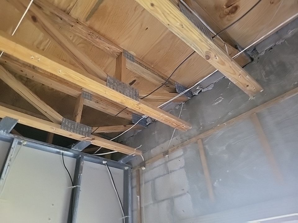 Exposed roof trusses and block walls after ceiling removed during fire damage restoration